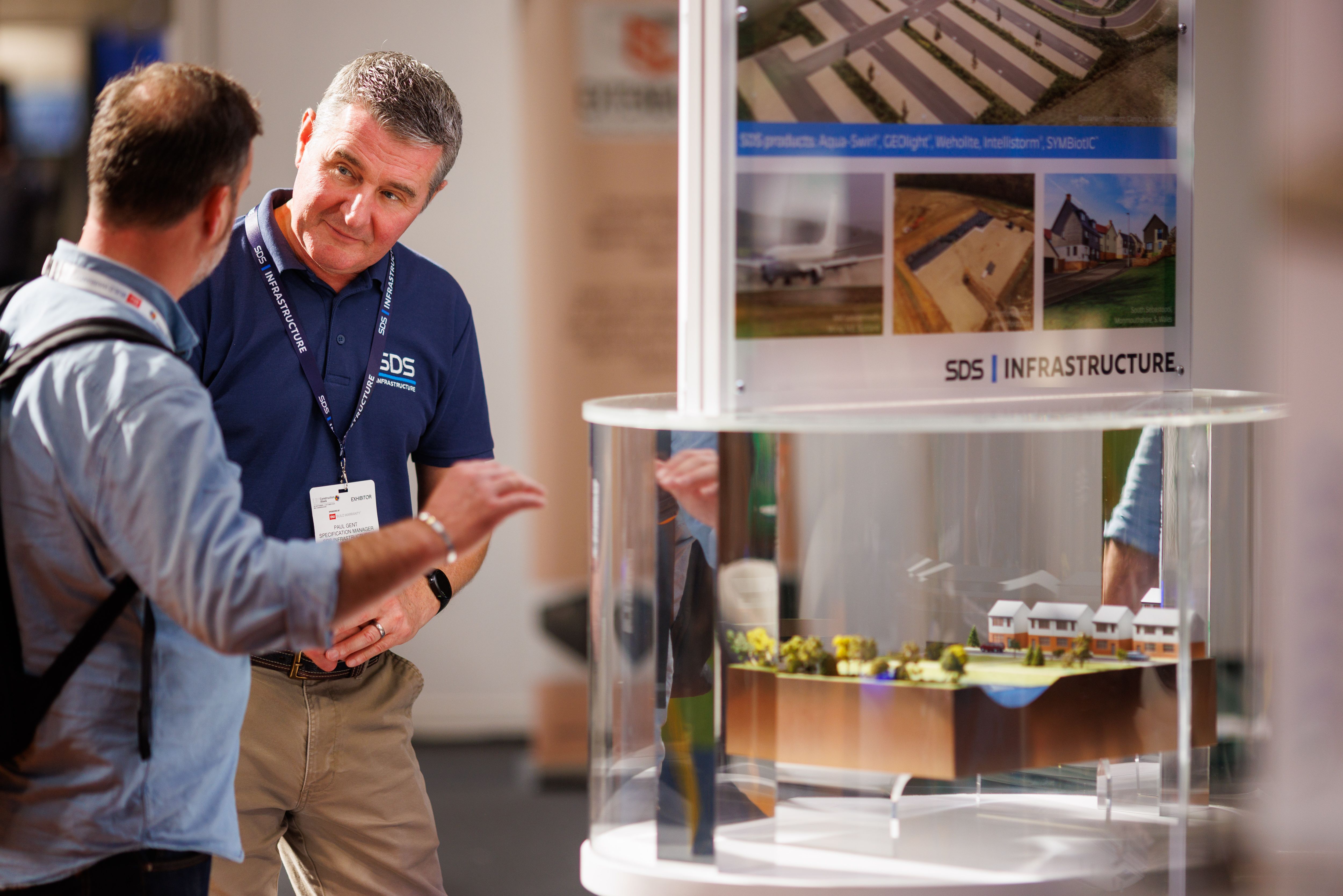 UK Construction Week Exhibitor talking with a visitor